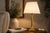 An elegantly proportioned brass table lamp in the classical column form, combining a tall cylindrical stem with richly...
