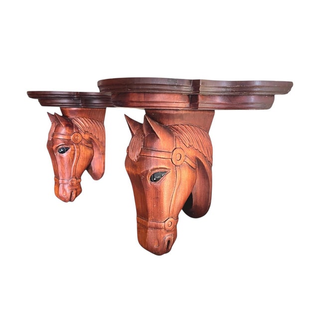 A nicely carved pair of wood corbel shelf wall brackets in the form of horse heads with a two tiered top. Small hole on...