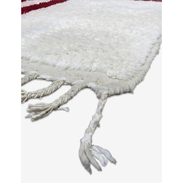 Contemporary Moroccan Rug | Handwoven Berber Wool Rug with Ivory Field and Burgundy Stripe Composition This clean...