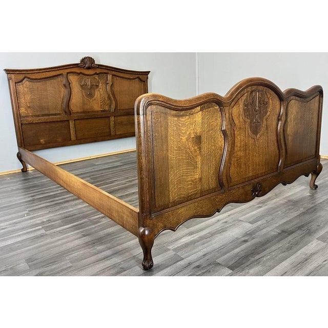 This Vintage French Louis double bed frame features elegant curved lines, decorative carved panels, and a rich oak wood...