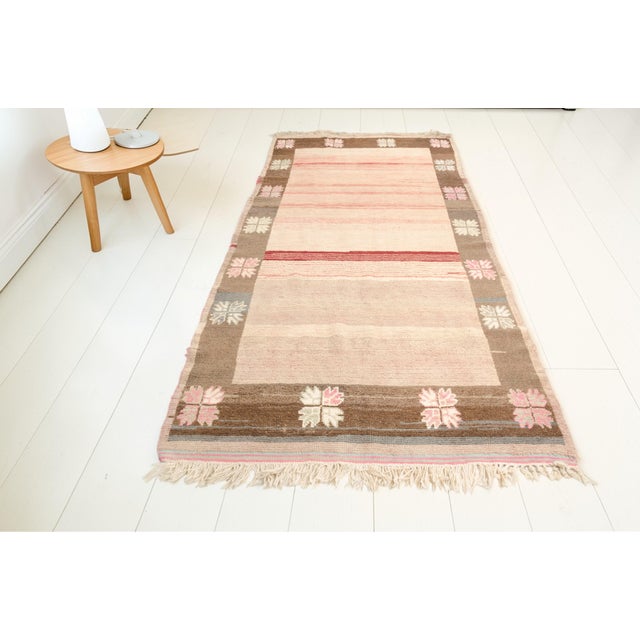 This is a vintage Turkish Oushak rug from the Mid 20th Century. The piece was hand-knotted.