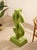 A bold sculptural dollar sign cast in concrete and finished in a punchy lime green. The oversized symbol sits on a...