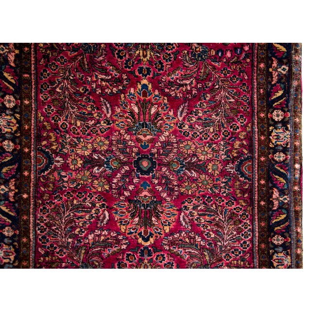 A beautiful early 20th century Persian Sarouk runner with a large-scale mirrored floral pattern containing myriad floral...