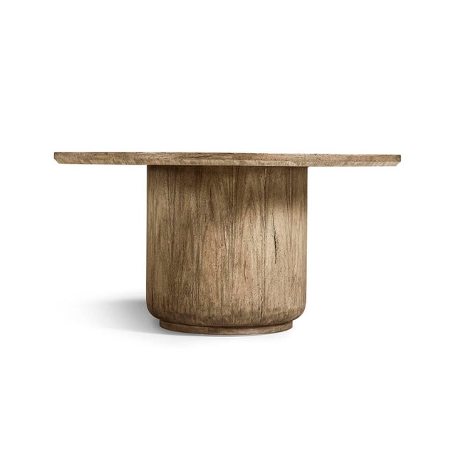 The Dining Table stands out as a sculptural centerpiece with its wide circular top and solid cylindrical base. Made from...