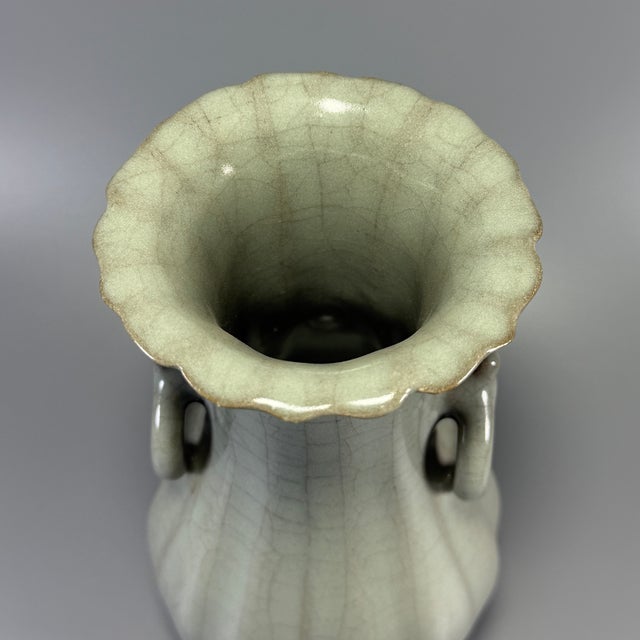 A vintage‑style Chinese Longquan celadon lobed vase, with flared flower‑shaped rim and two pierced ring‑shaped side...