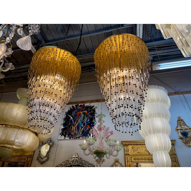 A pair of beautiful Italian mid-century modern, glass beaded chandeliers. The brand and maker is unknown. Dimensions: 36"...