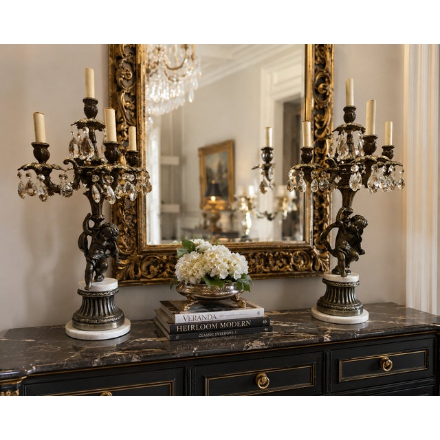 A dramatic matching pair of large vintage Hollywood Regency five-light candelabra table lamps featuring sculptural cherub...