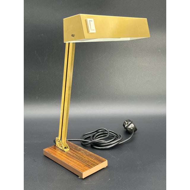 This elegant banker's lamp from Pfäffle combines a high-quality brass look with a warm wood veneer base, bringing timeless...