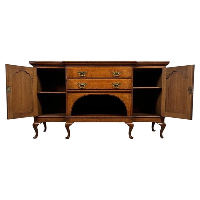 A handsome early 20th-century English sideboard, finely crafted from oak and distinguished by its substantial proportions,...