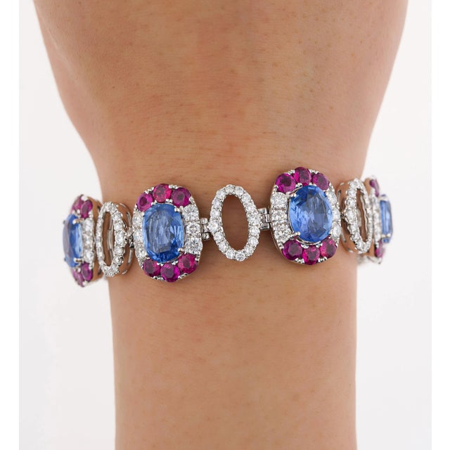 18k white gold oval shaped multi gemstone link bracelet. Featuring 7 oval cut no heat natural blue sapphires. Each of...