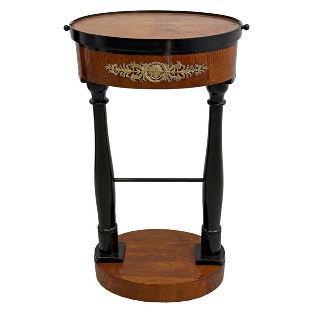 Elegant Empire sewing table dating from the first half of the 19th century. Crafted in ash veneer with contrasting black...