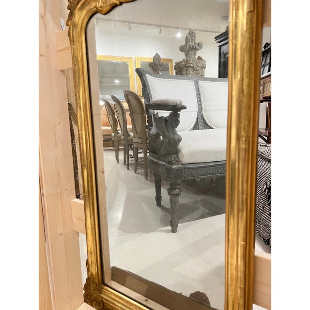 A graceful 18th-century Swedish Rococo mirror crafted in giltwood, featuring elegant curves, delicate hand-carved...