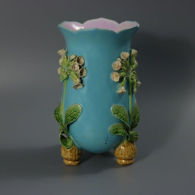 Minton Majolica vase which features flowers and leaves sprouting from bulb feet. Turquoise ground version. Colouration:...