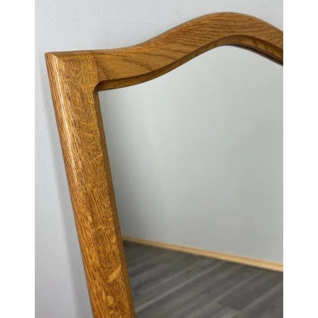 A charming Vintage French oak wall mirror featuring a gently curved frame and warm natural oak tone. Its simple yet...