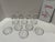 Decorative set of 12 clear glass coasters featuring frosted zodiac symbols representing the astrological signs. Each...