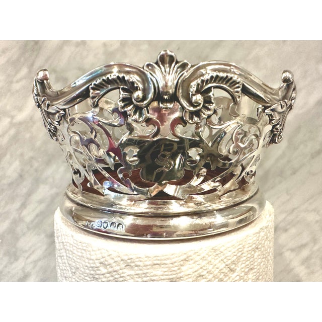 An exquisite pair of antique English, fully hallmarked, sterling silver wine coasters, each with pierced foliate sides, an...