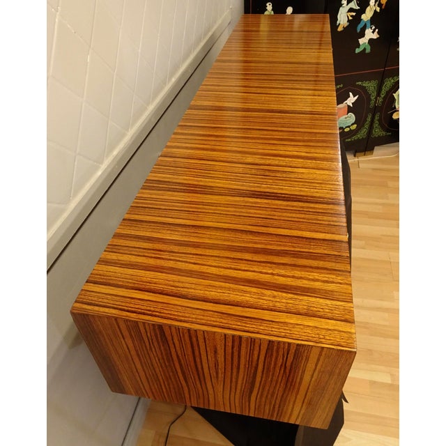 Spectacular floating sideboard with waterfall zebrawood veneer, solid brass pulls and all oak panel inners in the drawers....