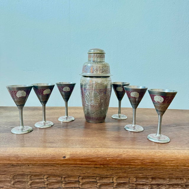 This is a decorative cocktail shaker set with an intricate etched design, including a peacock and floral motif, most...