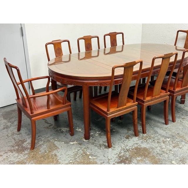 Design Plus Gallery presents a Rosewood Extension Dining Table + Eight Rosewood Dining Chairs. All the chair backs display...
