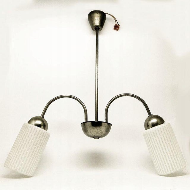 The chandelier was manufactured in Poland in the 70s. The lamp is made of metal and milk glass. It is preserved in very...