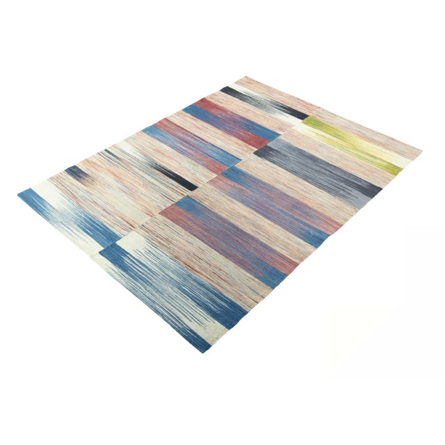 This handwoven designer kilim combines traditional craftsmanship with modern design. The striking striped pattern in bold...