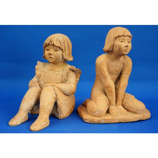 MEASUREMENTS: Seated girl: Height: 16 cm; Width: 14 cm; Depth: 10.5 cm; Kneeling girl: Height: 17.5 cm; Width: 13.5 cm;...