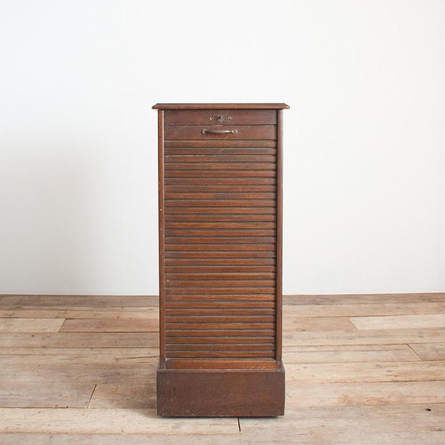 An original antique single tambour. The tambour retains its original brass pull handle and key. The tambour front will...