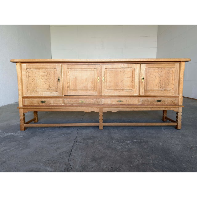Large Danish Modern sideboard in solid oak and oak veneer, crafted in Denmark circa 1960s. This beautifully proportioned...