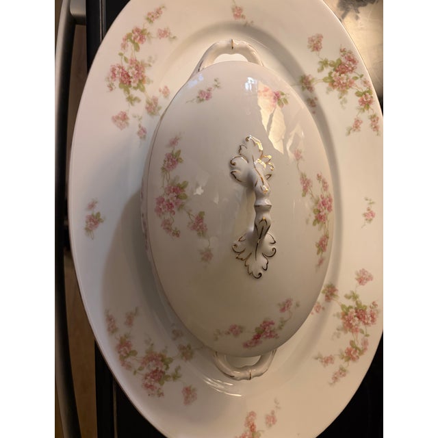 An exquisite antique porcelain covered soup tureen resting on its matching large presentation underplate platter, produced...