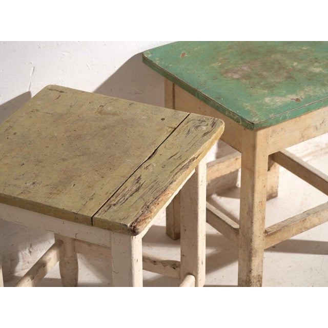 A pair of antique bedside tables in pine wood, with a square top and four tapered legs tied by box stretchers. They...