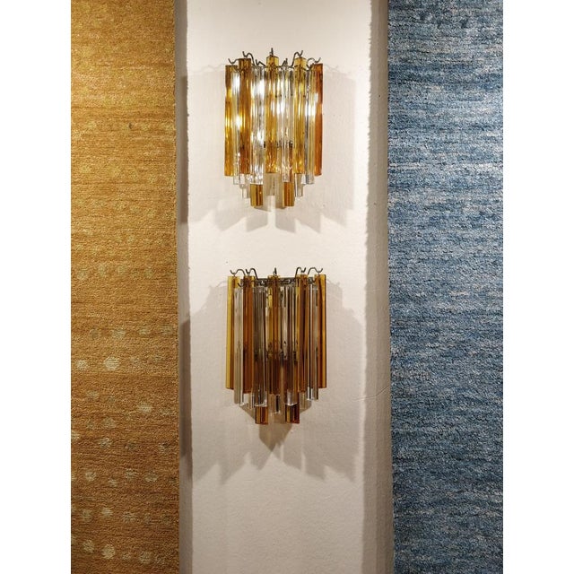 A stunning pair of Murano glass wall lamps by Venini, crafted in the 1970s. Featuring an elegant contrast between orange...