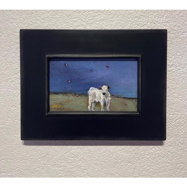 In "Starry Sky," a solitary white calf stands against a deep blue night, its textured fur reflecting the subtle glow of...