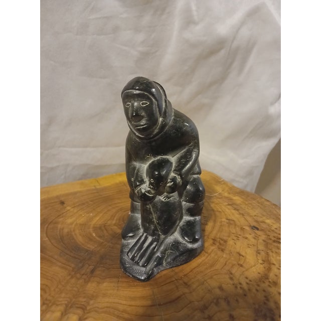 This vintage Inuit Soapstone carving depicts a hunter with a seal. These sculptures are typically handcrafted from dark...