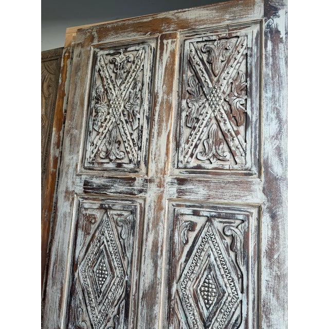 Infuse your space with old-world character using this distressed hand-carved wooden barn door, accented with bold metal...