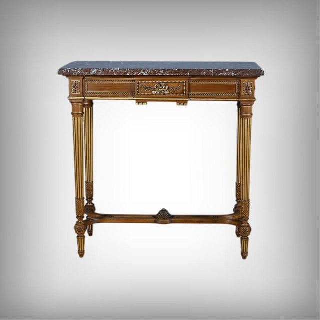 An elegant console table in molded and carved mahogany, partially gilded, exquisitely illustrating the neoclassical...