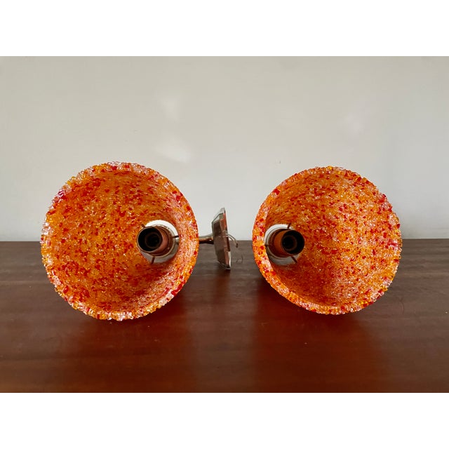 Pair of aryclic glass wall lights from the 1950s/60s Textured orange, white, and red acrylic glass shades and silver-tone...