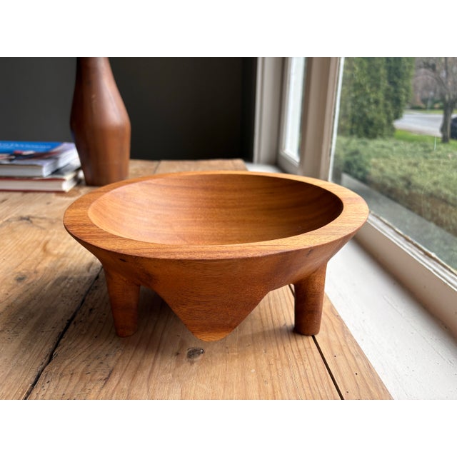 Beautiful hand-carved wooden bowl featuring a sculptural four-leg base and warm natural grain throughout. Crafted from...