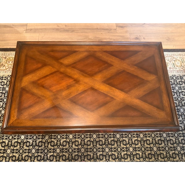 Rectangular coffee table with a lattice parquetry top inside a raised molded border, rounded flame mahogany apron, and...