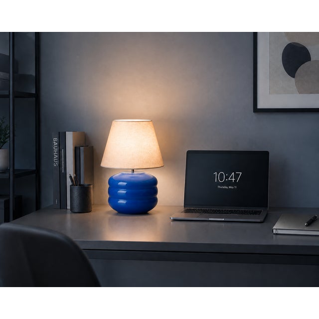 Crafted with high visual clarity, this modern table lamp features a sleek silhouette with a hand-blown glass base paired...