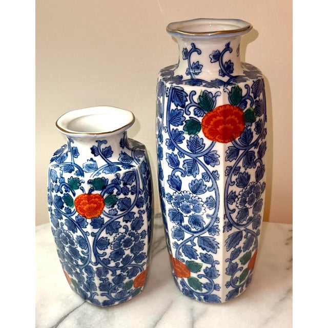 A pair of mid-century vases with a cobalt blue, white and vibrant red rose pattern. Hexagonal in shape, the vases measure:...