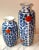 A pair of mid-century vases with a cobalt blue, white and vibrant red rose pattern. Hexagonal in shape, the vases measure:...