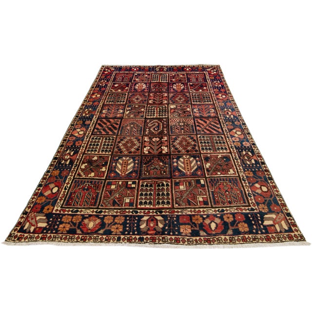 Beautiful Antique Bakhtiari hand-knotted wool rug with a rust color field. This Persian piece has an all-over classic...
