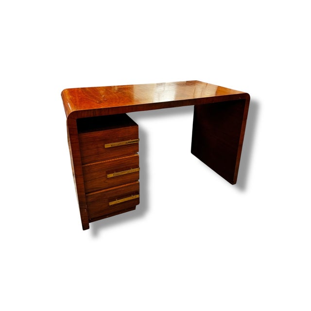 Striking vintage Art Deco waterfall desk featuring the signature curved edges and rich wood grain that define the era. The...