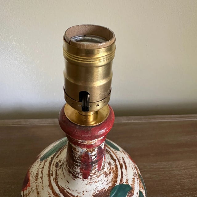 Vintage small ceramic lamp with a hand painted floral/rose design. Dominant colors are red, green, and brown, with hints...