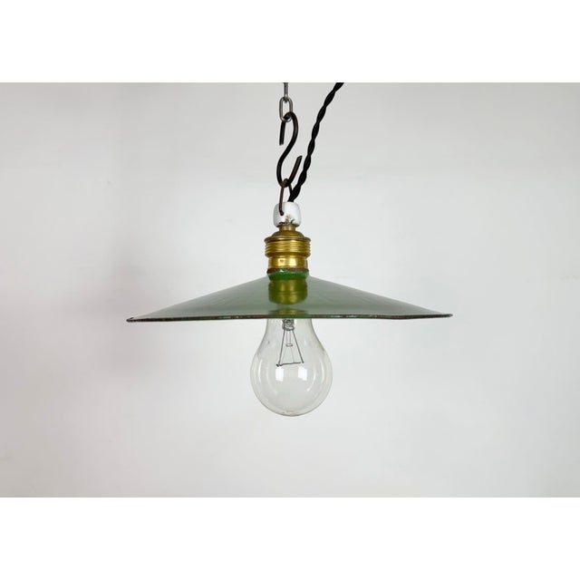 Vintage industrial enamel pendant lamp from the 1930s. It features a green enamel shade with white enamel interior and a...