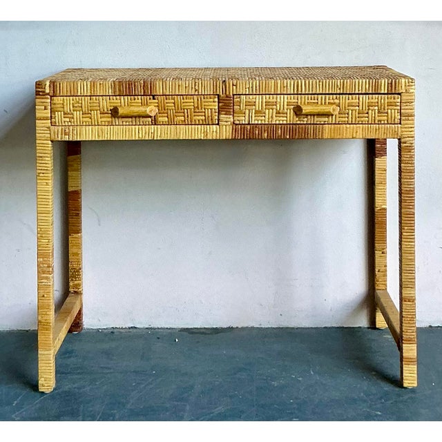 This charming vintage console table, constructed primarily of intricately woven rattan and slender pencil reed, epitomizes...