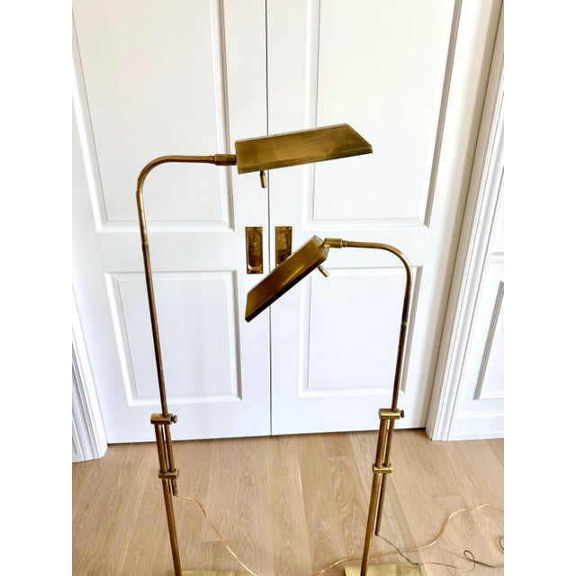 Pair of Frederick Cooper adjustable brass pharmacy floor lamps. They embody the refined, understated luxury for which the...
