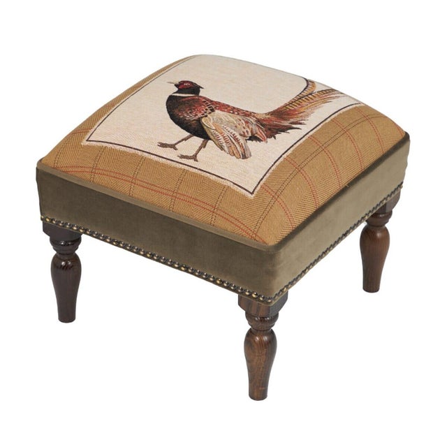 Meticulously handcrafted in the United Kingdom, this upholstered stool boasts classic studding and hand-polished solid...