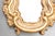 This is a charming Italian Rococo-style wall mirror featuring a richly carved and hand-applied gold leaf frame with...