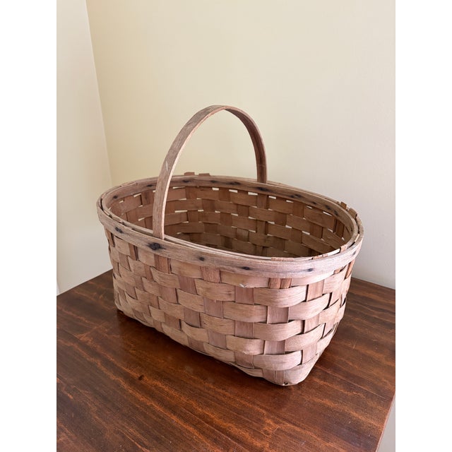 A beautifully handwoven early 20th century split oak basket with generous scale and a wonderfully time-softened surface....